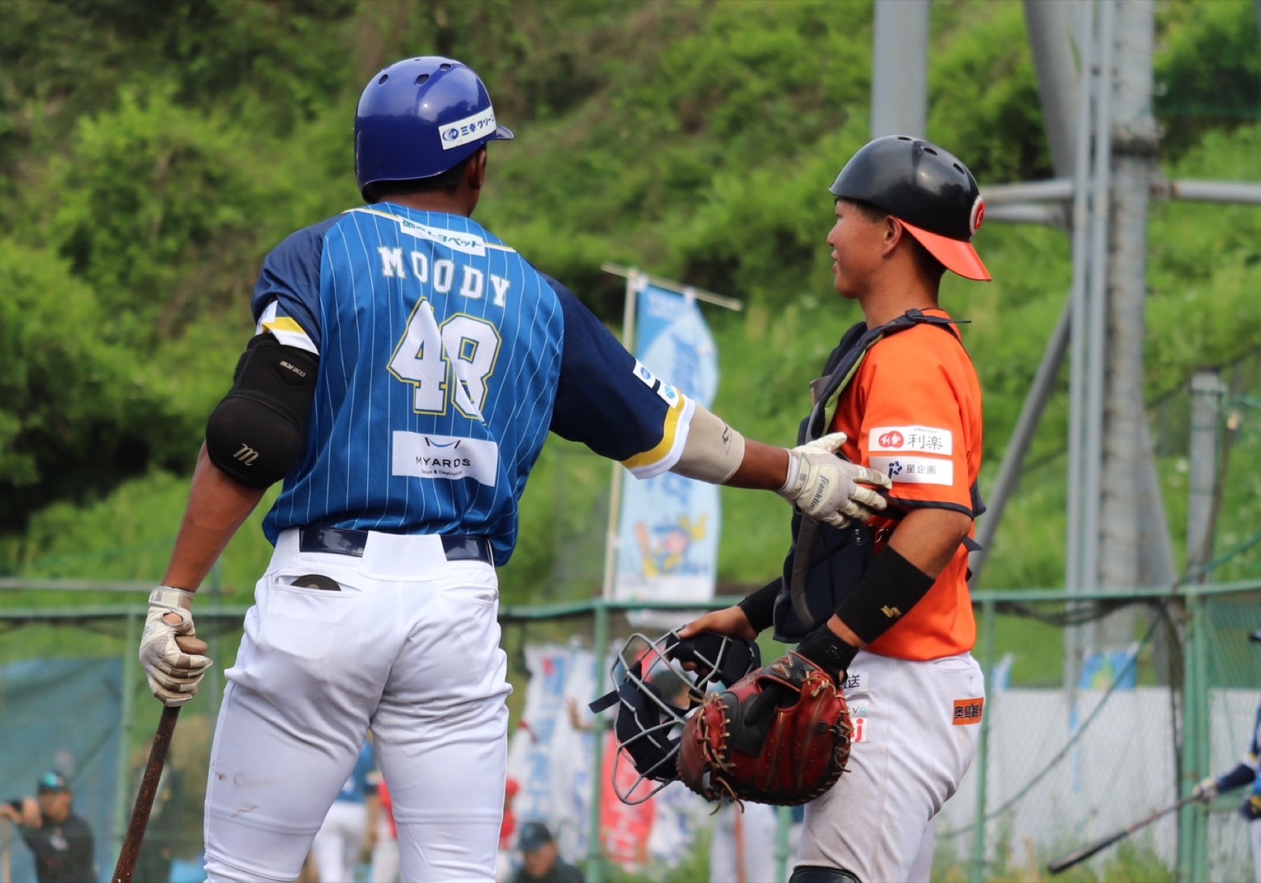 Players from opposing teams greeting each other on the field